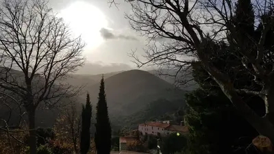 a view of a mountain with the sun in the sky at Gites-Terroirs-Occitanie in Felluns