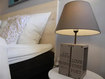 a lamp sitting on a table next to a bed at Gites-Terroirs-Occitanie in Felluns