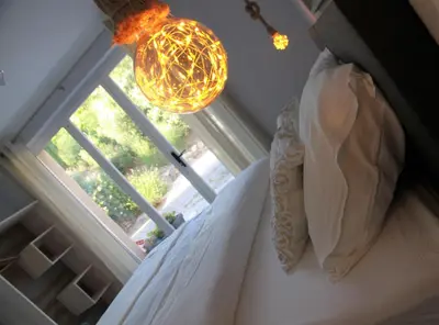 a bedroom with a bed with a window and a chandelier at Gites-Terroirs-Occitanie in Felluns