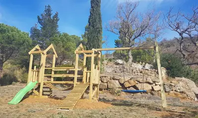 a wooden playground with a slide and a swing at Gites-Terroirs-Occitanie in Felluns
