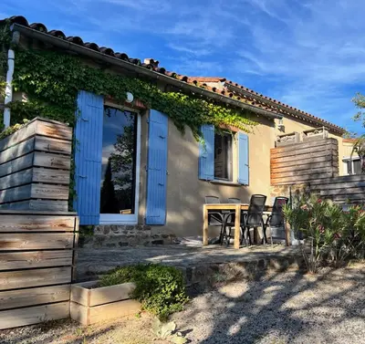 a house with a table and chairs in front of it at Gites-Terroirs-Occitanie in Felluns