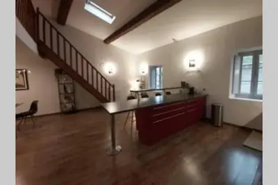 a living room with a table and a staircase at Le 68b in Carcassonne