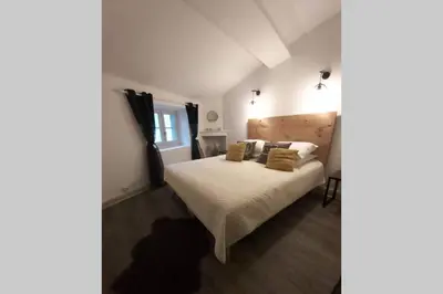 a bedroom with a bed with white sheets and pillows at Le 68b in Carcassonne
