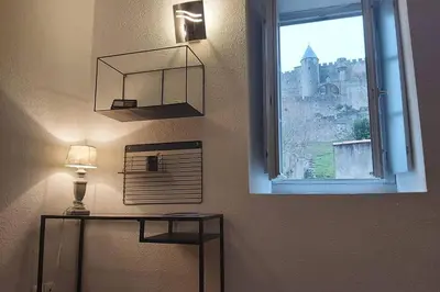 a room with a window and a table with a lamp at Le 68b in Carcassonne