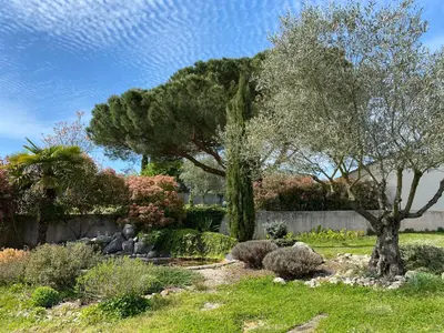 a garden with a statue and trees and bushes at Gîte du Mercadal Les Pujols in Pamiers