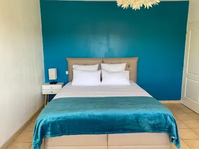 a blue bedroom with a bed with a blue wall at Gîte du Mercadal Les Pujols in Pamiers