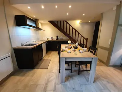 a kitchen with a table with chairs and a sink at Gîte confortable avec SPA privé et confort moderne in Pont-de-Larn