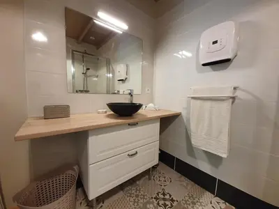 a bathroom with a sink and a mirror at Gîte confortable avec SPA privé et confort moderne in Pont-de-Larn