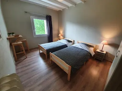 a bedroom with two beds and a window at Gîte confortable avec SPA privé et confort moderne in Pont-de-Larn