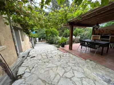 a patio with a table and a stone walkway at L'Ancienne Forge in Villarzel-du-Razès