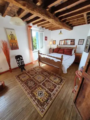 a bedroom with a bed and a rug in a room at L'Ancienne Forge in Villarzel-du-Razès