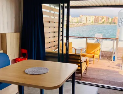 a room with a table and chairs on a boat at Les Ilots de Gruissan in Gruissan