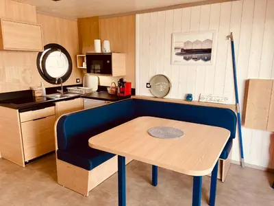 a small kitchen with a table and a blue couch at Les Ilots de Gruissan in Gruissan