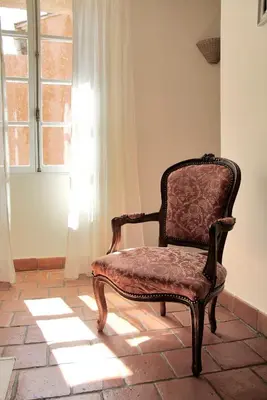 a chair sitting in a room with a window at Le Coq du Nord - Mailhac Gîte et Chambres d'Hôtes in Mailhac