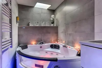 a bathroom with a bath tub with lights in it at Le bourget - Suite romantique in Narbonne