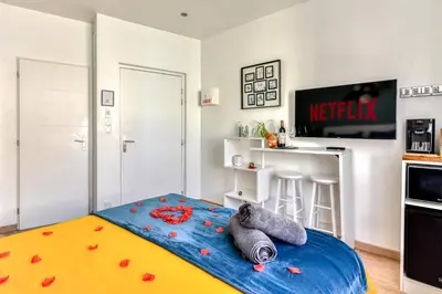 a room with a bed with red flowers on it at Le bourget - Suite romantique in Narbonne