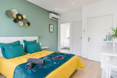 a bedroom with a bed with a yellow and blue blanket at Le bourget - Suite romantique in Narbonne