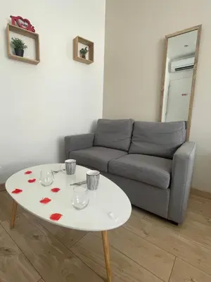 a living room with a couch and a white table at Le Bourget - Envolée Romantique in Narbonne