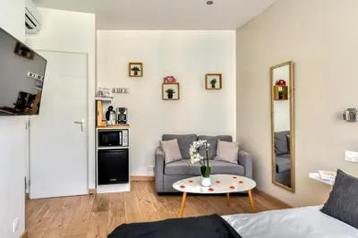 a living room with a couch and a table at Le Bourget - Envolée Romantique in Narbonne