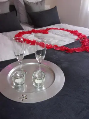 a tray with two wine glasses on top of a bed at Le Bourget - Envolée Romantique in Narbonne