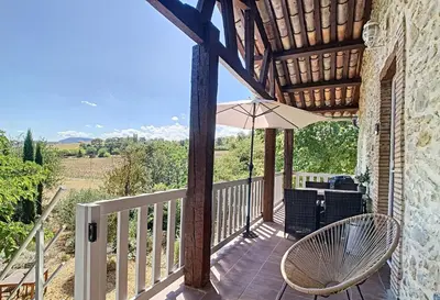 a balcony with a table and an umbrella at Gîte - Holiday Home Vent Marin in Limoux
