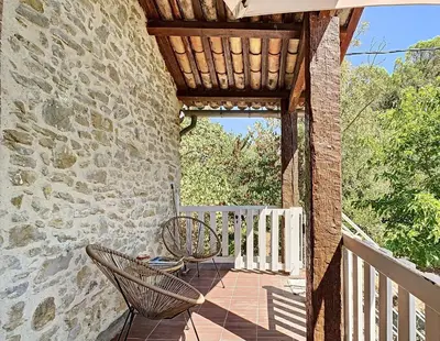 a patio with a table and chairs on a stone wall at Gîte - Holiday Home Vent Marin in Limoux