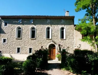 a large stone building with a red door at Gîte - Holiday Home Vent Marin in Limoux