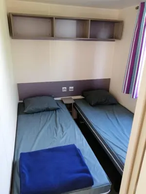 a small room with two beds and a desk at Mobil Home climatisé 6 personnes in Port-la-Nouvelle