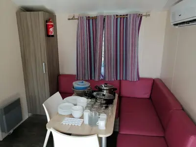 a living room with a pink couch and a table at Mobil Home climatisé 6 personnes in Port-la-Nouvelle
