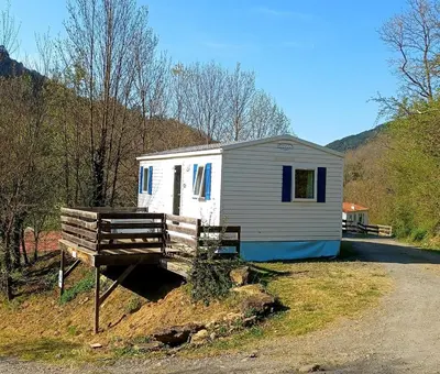 a tiny house with a bench in front of it at Camping La Bernede in Rennes-les-Bains