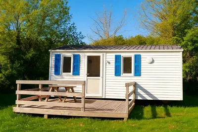 a white tiny house with a wooden deck at Camping La Bernede in Rennes-les-Bains