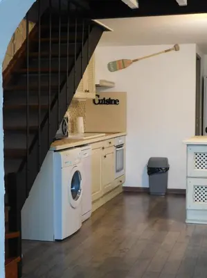 a laundry room with a washer and a staircase at LA MAISON DU LAC climatisée et WiFi gd F3 in Port-la-Nouvelle