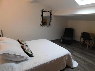 a bedroom with a white bed and a chair at LA MAISON DU LAC climatisée et WiFi gd F3 in Port-la-Nouvelle