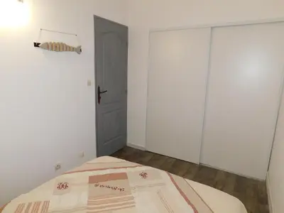 a white bedroom with a bed and a door at LA MAISON DU LAC climatisée et WiFi gd F3 in Port-la-Nouvelle