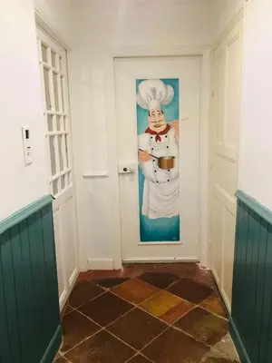 a door with a picture of a chef on it at Aux Berges du Libre in Félines-Termenès
