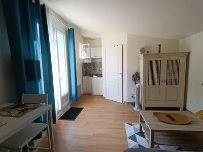 a living room with a table and a kitchen at Studio indépendant au calme avec parking privatif in Caucalières