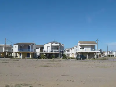 a row of houses on the beach with a car at Apartment Les Portes de la Plage by Interhome in Gruissan