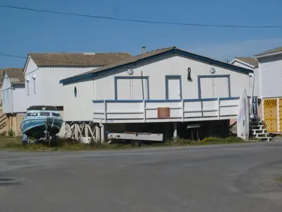 a white house with a boat in front of it at Apartment Les Portes de la Plage by Interhome in Gruissan