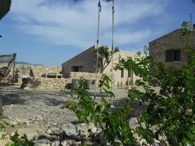 a house in the middle of a rocky yard at Mas des 4 Vents in Fitou