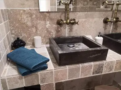 a bathroom with a black sink and a blue pillow at Le 9 de Cour, Chambre Chaco in Carcassonne