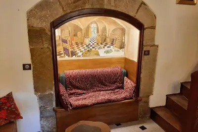 a room with a chair in a room with a painting at MAISON DE NOSTRADAMUS*** OCCITANIE INSOLITE in Alet-les-Bains