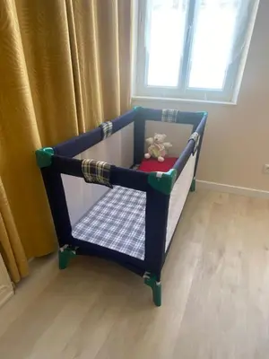 a toy crib with a teddy bear in a room at Chambre privée au calme excellente prestation in Castelnaudary