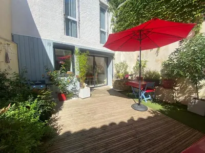 a red umbrella sitting on top of a wooden deck at Chambre privée au calme excellente prestation in Castelnaudary