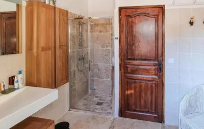 a bathroom with a shower with a wooden door at Cozy Home In Pouzols-Minervois in Pouzols-Minervois