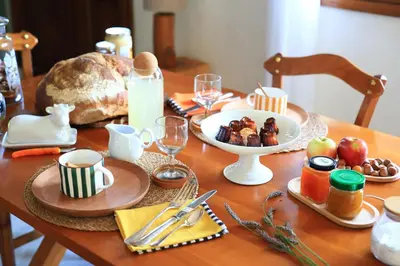 a wooden table with a table with food on it at A l'Ecole Buissonnière, chambre d'hôtes en Sidobre in Lacrouzette