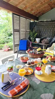 a table with plates of food on a patio at A l'Ecole Buissonnière, chambre d'hôtes en Sidobre in Lacrouzette