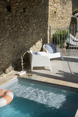a patio with two chairs and a swimming pool at La Bastide Saint Etienne in Cournanel