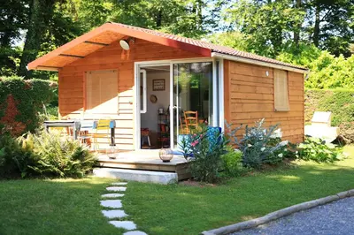 a small cabin with a porch in a yard at Chambre d'hôtes cosy Le Chalet -Tarn in Lacrouzette