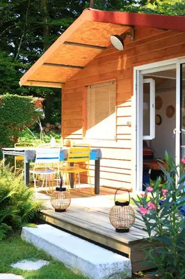a cabin with a table and chairs on a porch at Chambre d'hôtes cosy Le Chalet -Tarn in Lacrouzette