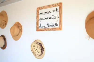 a group of hats and a sign on a wall at Chambre d'hôtes cosy Le Chalet -Tarn in Lacrouzette
